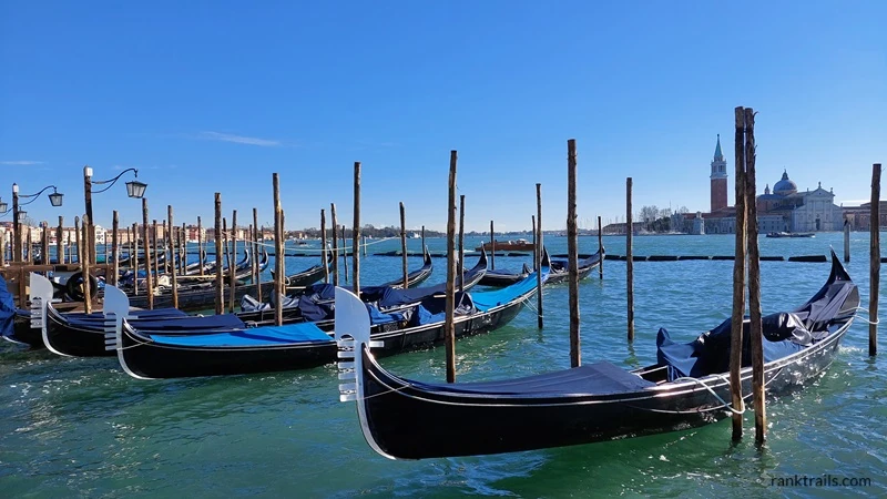 Gondolas docked on the Venetian lagoon, a popular starting point for a gondola ride in Venice.