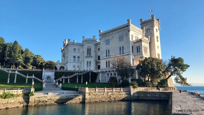 Miramare Castle in Trieste overlooking the Adriatic Sea with blue sky and waterfront view.