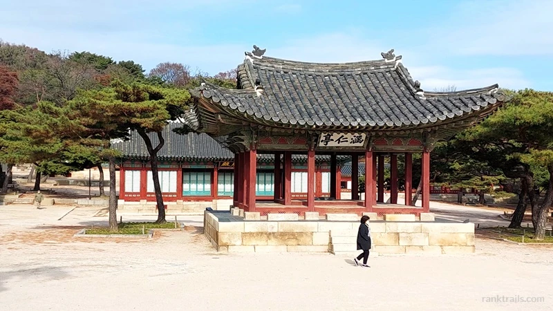 Traditional Korean temple building in Seoul surrounded by pine trees photographed by a travel blogger.