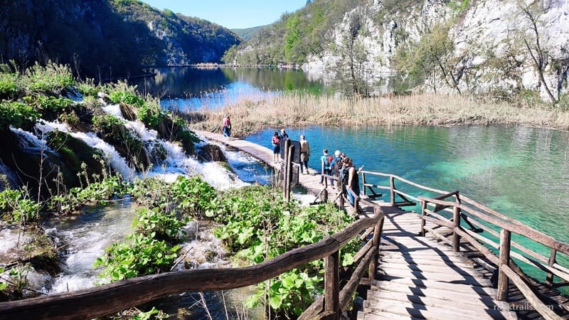 Wooden boardwalk over turquoise water and waterfalls in Plitvice Lakes National Park, Croatia