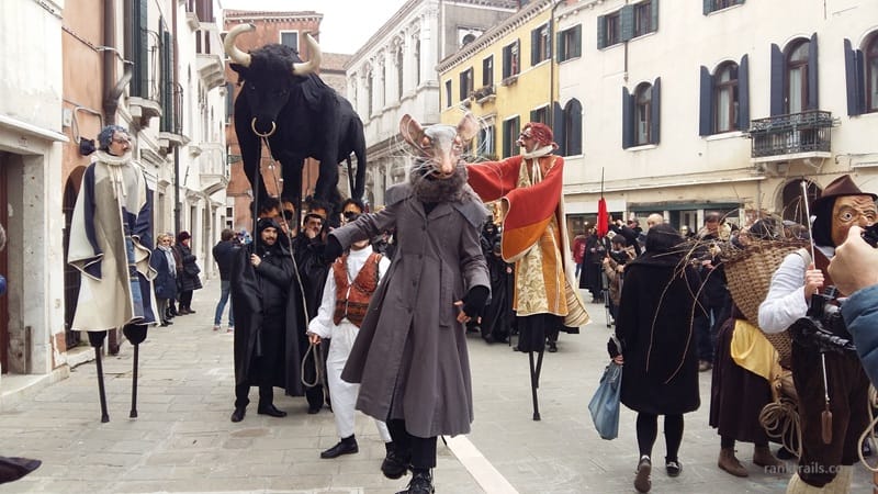 Costumed performers and giant puppets during the Venice Carnival street parade in Venice, Italy, in 2017